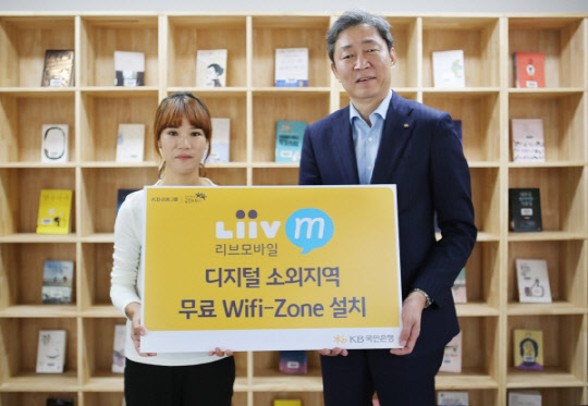 지난달 29일 완도군 조약도 소재 약산진달래 작은도서관에서 열린 'Liiv M 무료 와이파이존 개통식'에서 약산진달래 작은도서관 운영자 정순화씨와 (오른쪽)박상용 KB국민은행 사회협력부장이 기념촬영을 하고 있다. KB국민은행 제공